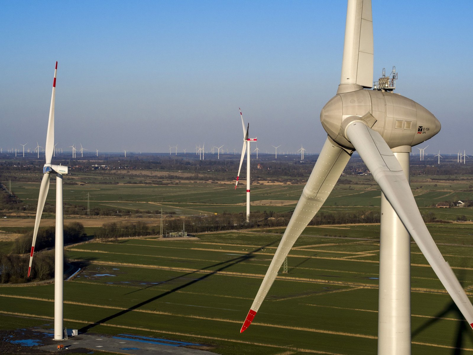 Windkraftanlagen auf gr&uuml;n-braunnen Feldern